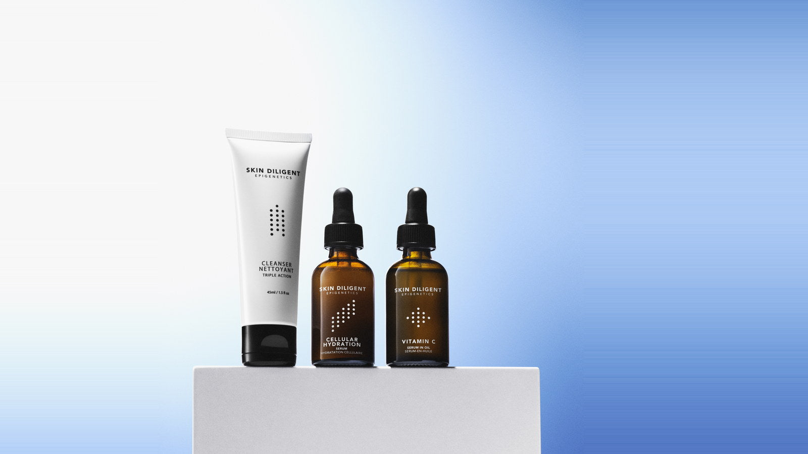 Skin Diligent Triple Action Cleanser, Cellular Hydration Serum and Vitamin C Serum-in-Oil standing together, three finished formulas